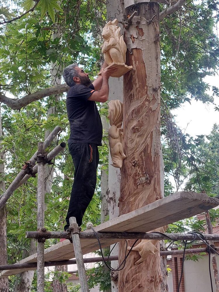 نقشآفرینی بر تنه درختان خشک باغ فردوس در آستانه غدیر